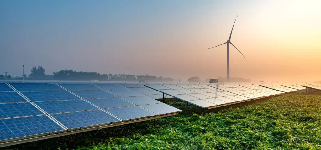 Solar panels and a wind turbine in a grass field